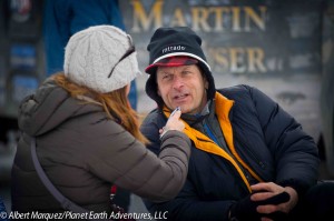 Emily Schwing, KUAC Fairbanks, interviews Martin at the restart. Photo: Albert Marquez/Planet Earth Adventures, LLC